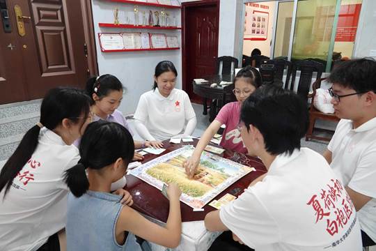 图为大家围坐桌前玩桌游,在欢声笑语中读懂四季农耕